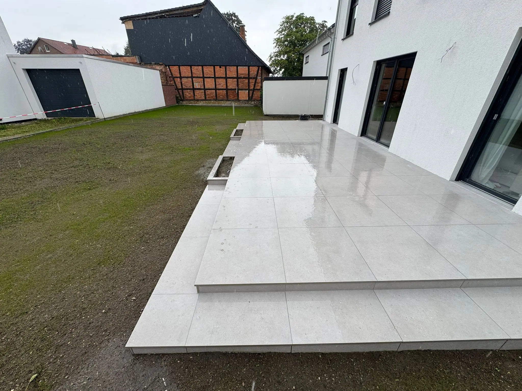 Terrassenstufenbau - Integrierte Stufen in grauen Großformat-Platten für harmonisches Design